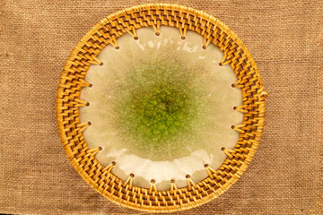 One ceramic plate on jute cloth, close-up, top view.