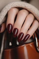 Poster - A close-up view features a woman's burgundy-painted nails grasping a leather handbag, showcasing long oval manicured nails with a refined French tip design. The scene embodies an oshare kei style