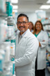 © Mariana Mejia - Smiling pharmacist assisting customers in pharmacy