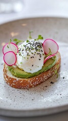 Wall Mural - Gourmet avocado toast on artisanal sourdough topped with thinly sliced radishes, poached egg and sprinkle of black sesame seeds on white ceramic plate.