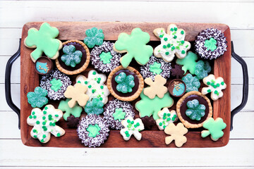 Poster - St Patricks Day shamrock dessert board. Green cookies and sweets. Overhead view on a rustic wood background.