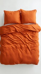Leinwandbilder - An overhead view showcases a textured orange duvet cover with matching pillows, elegantly styled on a pristine white background, embodying a minimalist design philosophy perfect for modern decor