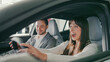© ihorvsn - Funny female sitting in drivers seat. Exclaiming and laughing while trying out everything in new car. Manager sitting next to woman and smiling. Happy customer. Girl talking and asking questions.