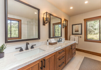 Wall Mural - A double-sink bathroom with two large wall mirrors, minimalist black metal sconces hanging above the sleek white marble countertop and the wooden cabinetry