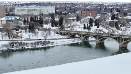 Wall Mural - Bridge over a river with snow on the ground. The bridge is covered in ice and snow