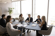 © fizkes - Six laughing teammates sit at table in high rise office conference room take part in corporate briefing or educational seminar, joking, enjoy friendly communication. Success, business training event