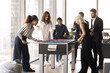 © fizkes - Group of happy multiethnic colleagues playing foosball, fighting table soccer, having fun, enjoying office leisure during lunch break. Friendship and recreational activity at workplace, stress relief