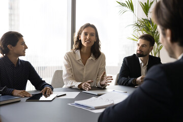 Canvas Print - Young confident businesswoman providing update on progress of project she leading, presenting new ideas or proposal, sharing strategy, discussing challenge, suggesting potential solutions of issues