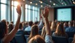 © Maryna - Audience members actively participate in seminar by raising hands. Many people listen, engage in modern conference venue. Well-lit room shows audience engagement. Attendees show interest, ask