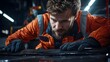 © Ratchadaporn - Close up view of a technician or mechanic closely inspecting and examining a carbon fiber automotive spoiler part under the bright lights of a workshop or garage setting