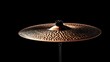 © BerkahStock - Close-up of a bronze cymbal on a black background.