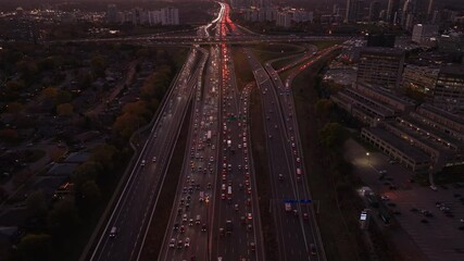 Wall Mural - Heavy traffic on Highway 401 and 404 in Ontario at dusk, with city lights glowing