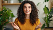 © NAD SANG PAP - young woman with curly hair enthusiastically discussing ideas in cozy indoor setting filled with plants
