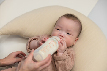 Wall Mural - Baby drinking milk from a bottle