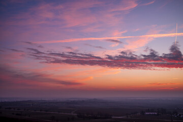 Wall Mural - pink sunrise clouds over a village