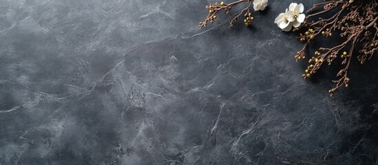 Poster - Textured porcelain tile surface with stone appearance against a dark gray backdrop featuring decorative floral elements and natural accents.