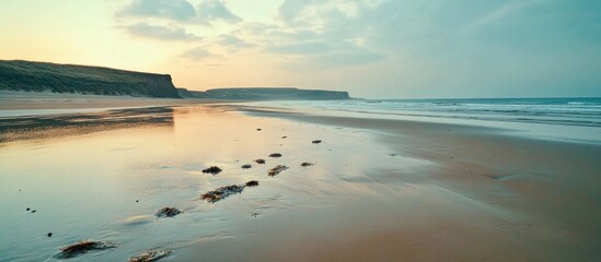 Poster - Tranquil North Sea Beach at Low Tide with Reflections and Footprints in Wet Sand during Sunrise