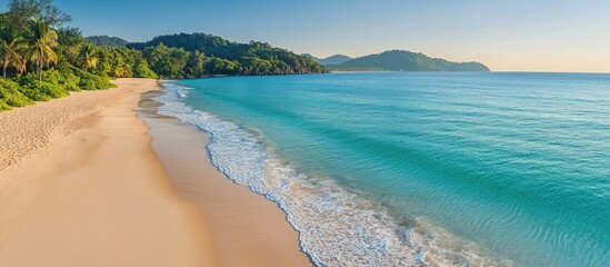 Poster - Panoramic view of a tranquil beach with golden sand, clear turquoise waters, and lush greenery under a bright blue sky.