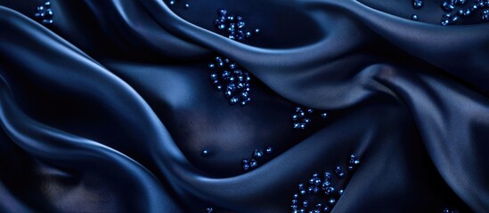 Poster - Elegant navy blue silk fabric with sparkling blue glass beads creating a textured background perfect for sophisticated design projects.