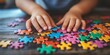 © Khawla - Banner, An autistic child`s hands play colorful jigsaw puzzle symbol of public awareness for autism spectrum disorder. autistic child`s hands playing a puzzle. World Autism Awareness day April 2