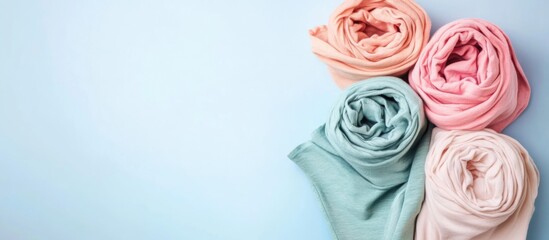 Poster - Rolled Cotton T Shirts in Pastel Colors with Empty Space for Custom Text or Branding on Light Blue Background