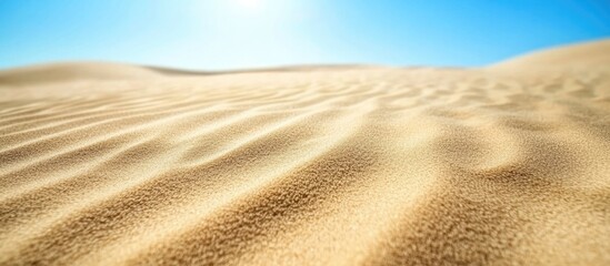 Poster - Mesmerizing sand texture background featuring gentle dunes under a bright blue sky creating a serene and tranquil desert landscape.