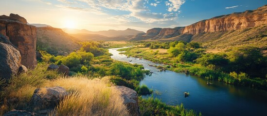 Aufkleber - Scenic canyon landscape featuring a winding river, rugged cliffs, and lush vegetation under a vibrant sky with space for text.