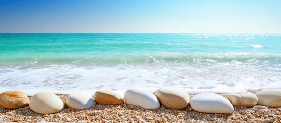 Aufkleber - Serene close-up of smooth stones along a vibrant ocean shoreline under a clear blue sky in Brighton peaceful coastal landscape.