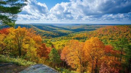 Poster - Vibrant autumn landscape showcasing rolling hills and colorful forests under a dramatic sky with clouds