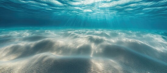 Canvas Print - Underwater sandy beach texture with soft light rays illuminating tranquil ocean floor and creating a serene marine atmosphere