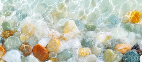 Aufkleber - Multicolored sea pebbles beneath gentle waves and foam on a tranquil summer beach scene.