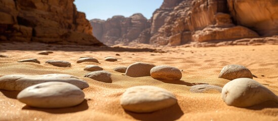 Aufkleber - Sandstone formations and smooth pebbles in a desert landscape under bright sunlight showcasing natural textures and colors.