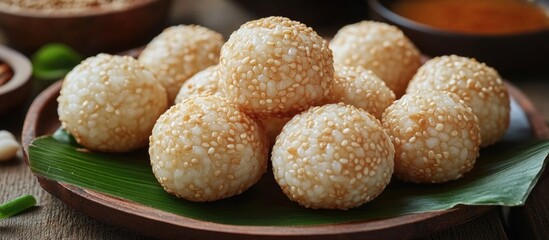 Canvas Print - Indonesian Onde Onde sesame-coated glutinous rice balls filled with mung bean served on a wooden plate with traditional snacks