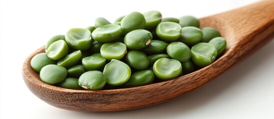 Wall Mural - Fresh green haricot beans in a wooden spoon isolated on a light background highlighting their natural texture and vibrant color.