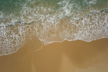 Wall Mural - Aerial view of sandy beach with gentle waves, turquoise water, and a small object on the shore