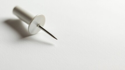 Poster - A simple yet striking close up captures a white push pin delicately placed on pristine note paper, symbolizing order and creativity. The light plays softly, enhancing the scene