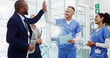 © peopleimages.com - Doctors, high five and celebration with team at hospital for breakthrough, diversity or happy for medical solution. Group, men and women with cheers, success or goal for healthcare services at clinic