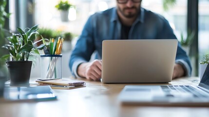 Poster - A focused man working on a laptop in a modern office with plants in the background : Generative AI