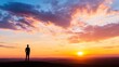 © Generative AI - Silhouette of a man standing on a hilltop watching a stunning sunset with colorful clouds and horizon : Generative AI