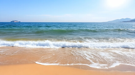 Wall Mural - tropical beach scene waves gently wash onto golden sand; mountain range in the distance under a brig