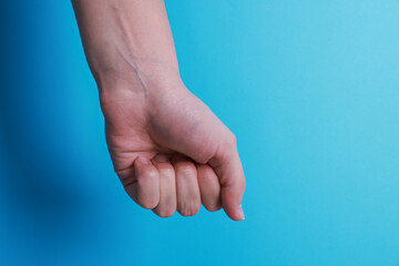 Wall Mural - Woman with visible hand veins on light blue background, closeup