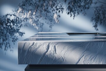 Aufkleber - A sleek, white marble countertop is showcased against a blurred backdrop of blue-toned branches, creating a serene and minimalist aesthetic.