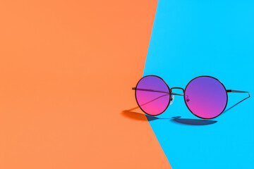 Poster - Reflective round lenses in hot pink and orange tones, lying on a layered, colorful texture, exuding