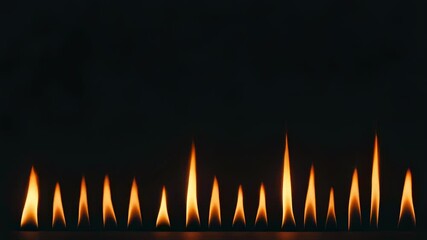 Poster - Small flames burning in the dark create a warm and inviting atmosphere, perfect for backgrounds or design elements related to fire, warmth, or energy