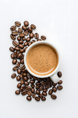 Wall Mural - Top view white cup of coffee with coffee beans scattered around it on a white background