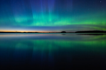 Wall Mural - northern lights dancing over calm lake in north of sweden. farnebofjarden national parrk