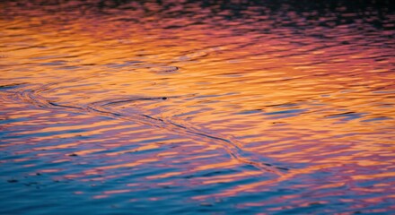 Poster - Sunset Water Reflections: Vibrant hues of orange, pink, and purple paint the surface of calm water, creating a mesmerizing abstract pattern of light and color at sunset. 