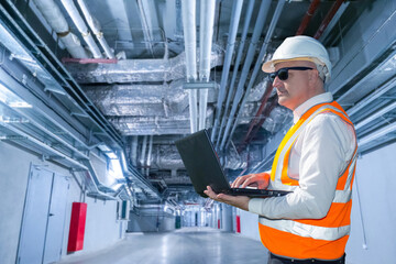 Poster - man controls work utilities. engineer with laptop in long corridor. engineering room in industrial b