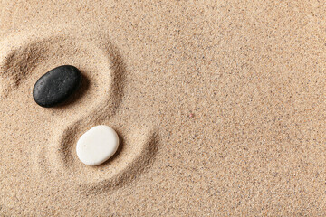 Wall Mural - Black and white spa stones on light sand. Zen concept