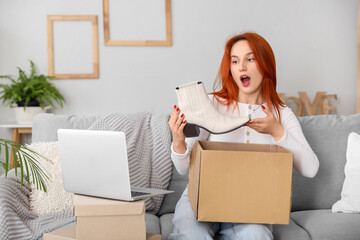 Wall Mural - Young woman unpacking new shoes at home